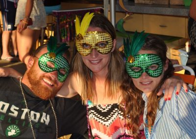 Three friends with Mardi Gras masks.