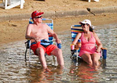 Couple sitting in chairs in the surf.