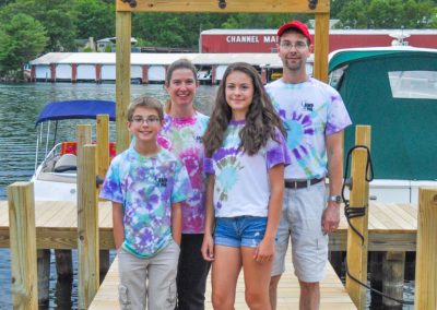 Family posing on the dock below the NASWA resort sign.