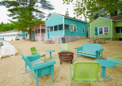Beach chairs and bench around a firepit.